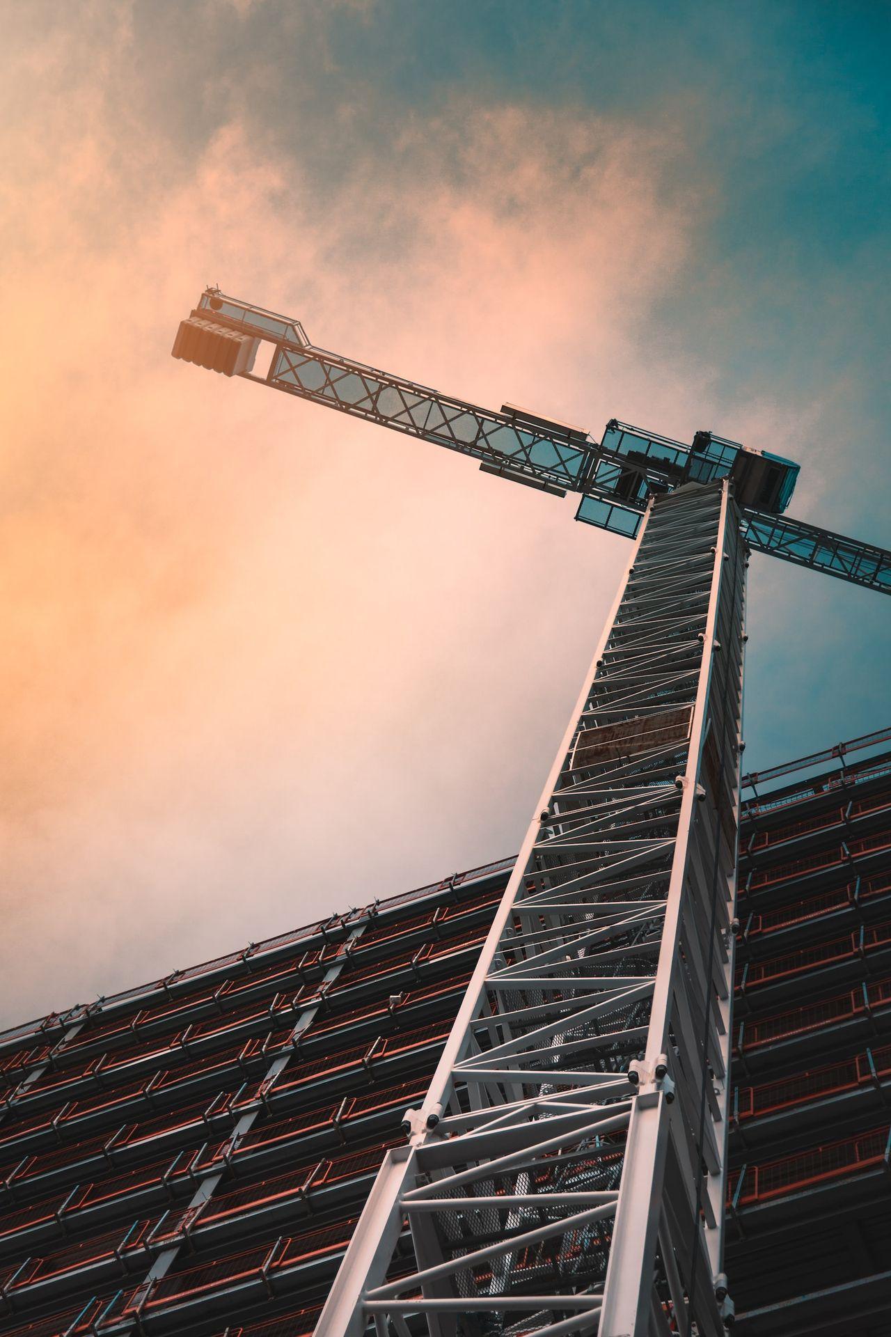 low angle photography of gray tower crane